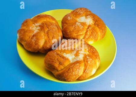 Ein frisch gebackener Brötchen mit einer knusprigen Krusteneingrenzung auf blauem Grund. Stockfoto