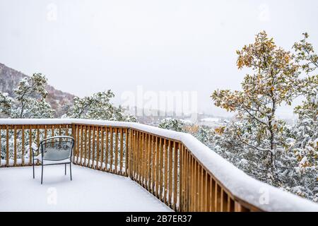 Haus Wohnung Immobilien mit Blick auf Boden und Herbstlaub auf Bäume mit schneebedeckten Blättern und Stuhl an Fenster Stockfoto