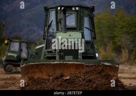 Ein US Marine Corps D6K Bulldozer mit Marine Wing Support Squadron (MWSS) 171 Level A Landing Zone während Defence Force Training 20.3 in Japan Ground Self Defense Force Camp Nihonbara, Japan, 9. März 2020. Marines mit MWSS-171 nehmen an einer zweiwöchigen Feldübung Teil, um ihre Fähigkeiten beim Aufbau einer vorderen Einsatzbasis, einer nach vorn aufragenden Bewaffnung und Auftankstelle sowie bei der Durchführung montierter Live-Feuerereignisse zu verbessern. (USA Foto des Marine Corps von Lance Cpl. Tyler Harmon) Stockfoto