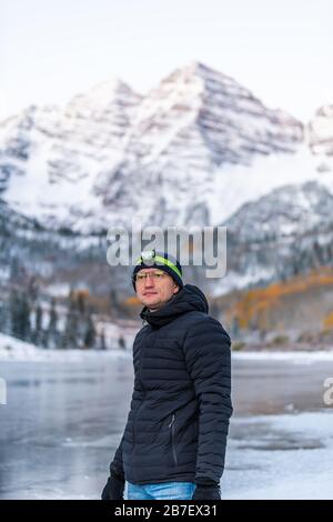 Maroon Bells Morgenaufgangsspitze mit Blick auf den Mann in Aspen, Colorado felsiger Berg und Herbst gelbes Laub und Winterschnee Stockfoto