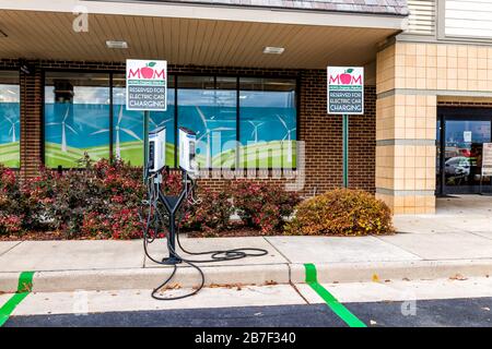 Herndon, USA - 12. November 2019: Außenparkplatz an der Fassade und Aufladung von Elektroautos im Bio-Markt von Mum mit frischen Agrar-Produkten auf Stree Stockfoto