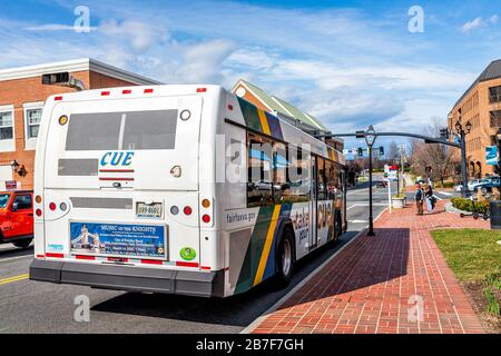 City of Fairfax, USA - 10. März 2020: City University Energysaver CUE Bus mit öffentlichen Verkehrsmitteln auf der University Drive mit Leuten, die auf b warten Stockfoto