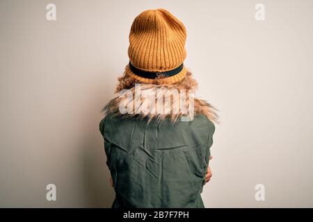 Junge afroamerikanische Skifahrerin mit lockigem Haar, die Schneesportkleidung trägt, und Skihoggles, die rückwärts stehen und mit gekreuzten Armen wegschauen Stockfoto
