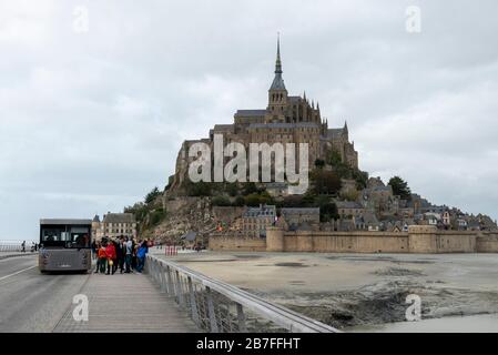 Bus mit Touristen auf der Brücke, die zum Berg Saint-Michel, Normandie, Frankreich, Europa führt Stockfoto