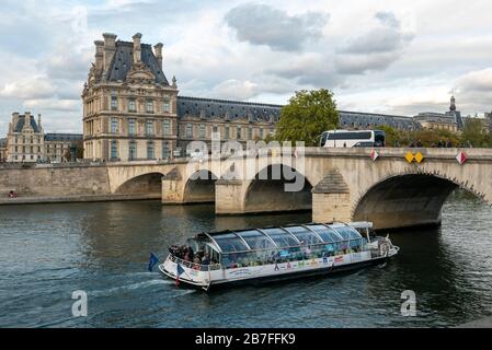 Bateau-mouche traditionelles pariser Ausflugsboot, das unter der Carrousel Brücke und am Louvre am Fluss seine, Paris, Frankreich vorbeiführt Stockfoto