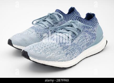 Zwei blaue, unbehaßte Adidas Ultraboost Laufschuhe sind auf weißem Hintergrund isoliert Stockfoto