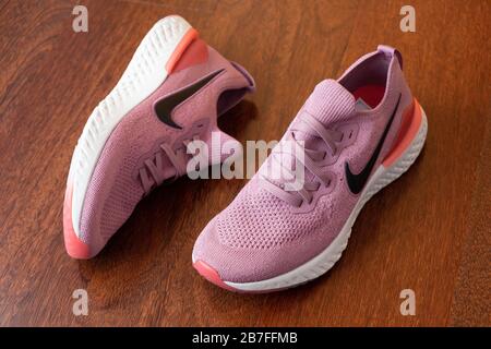 Paar pinke Nike Epic React 2 Laufschuhe auf Hartholzboden Stockfoto