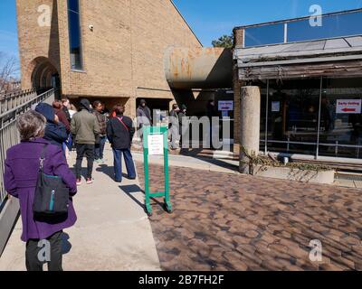 Oak Park, Illinois, USA. März 2020. Die frühen Wähler für die Wahl der Illinois Primary am Dienstag wurden getroffen, um sich heute außerhalb der Village Hall zusammenzuschließen, um zu vermeiden, dass sie im Gebäude zusammengedrängt werden. Auch Schulen und Bibliotheken sind bis zum 31. März geschlossen, um Coronavirus/COVID-19 von der Verbreitung fernzuhalten. Stockfoto