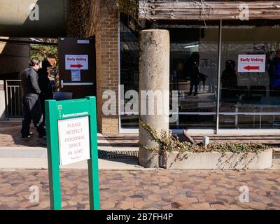 Oak Park, Illinois, USA. März 2020. Die frühen Wähler für die Wahl der Illinois Primary am Dienstag wurden getroffen, um sich heute außerhalb der Village Hall zusammenzuschließen, um zu vermeiden, dass sie im Gebäude zusammengedrängt werden. Auch Schulen und Bibliotheken sind bis zum 31. März geschlossen, um Coronavirus/COVID-19 von der Verbreitung fernzuhalten. Stockfoto