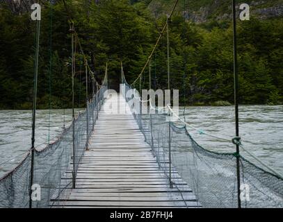 NATIONALPARK TORRES DEL PAINE, CHILE - CIRCA FEBRUAR 2019: Fußgängerbrücke über den Fluss Pingo im Torres del Paine National Park, Chile. Stockfoto