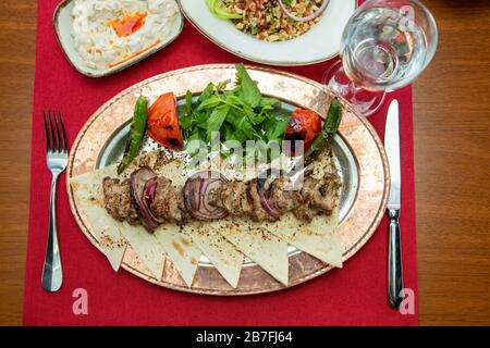 Das gebratene Raslik-Kebab auf Spießen liegt auf einem Gericht. Stockfoto Stockfoto