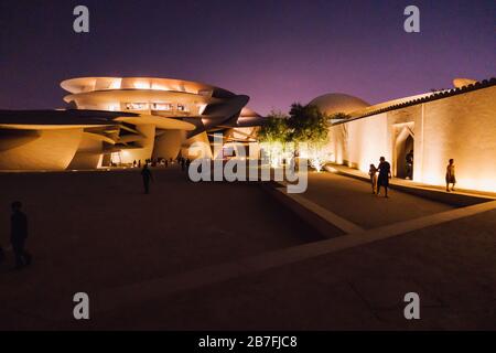 Nachtaufnahme des Nationalmuseums von Katar mit seinem markanten, auf Scheiben basierenden Design in Doha, Katar