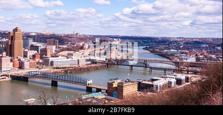 Teil der Innenstadt von Pittsburgh und Brücken über den Fluss Monongahela mit der University of Pittsburgh in der Ferne, Pittsburgh, Pennsylvania, USA Stockfoto