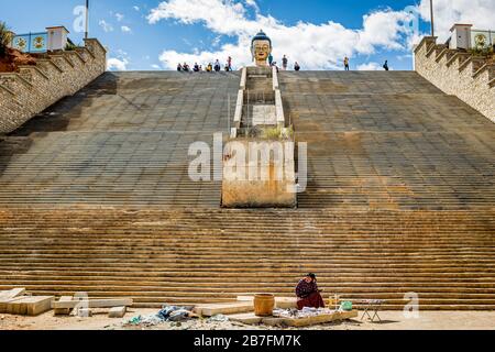 Dame zu Fuß der monumentalen Eingangstreppe zur Buddha-Dordenma-Statue (großer Buddha) in Thimphu, Bhutan Stockfoto