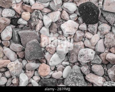 Kieselsteine getrocknete Flussfelsen, die zufällig auf das Ufer gesetzt werden, schließen Hintergrund. Stockfoto
