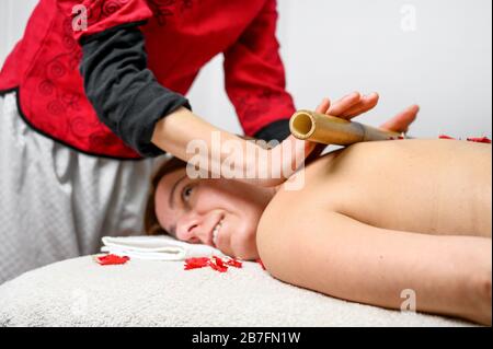 Frau mit Bambusstäbchen Massage im Day Spa. Stockfoto