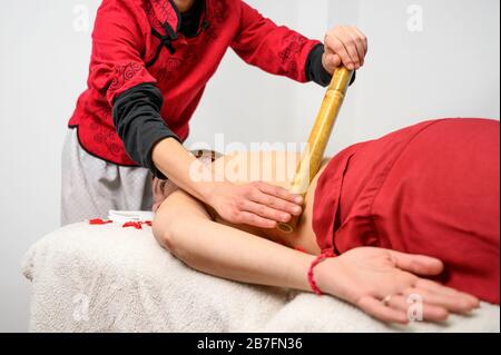 Frau mit Bambusstäbchen Massage im Day Spa. Stockfoto