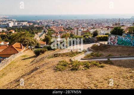 Blick über Thessaloniki in Richtung Thermaic Golf, vom Trigonion Turm aus gesehen. Ein gewundener Pflaster schlängelt sich den Hügel hinunter Stockfoto