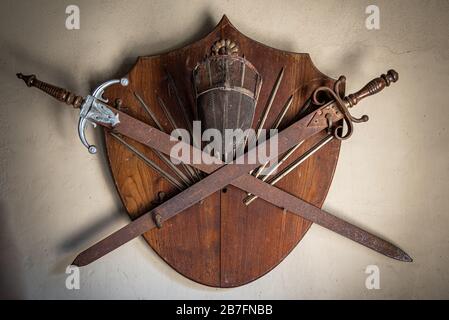 GONZALEZ CATAN, ARGENTINIEN, 28. SEPTEMBER 2019: Altes Holzschild mit zwei rostigen Schwertern und einem Fechthelm Stockfoto