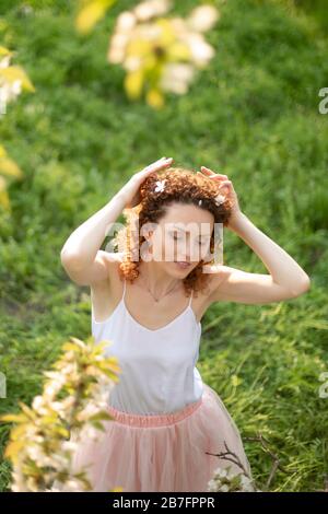 Junges attraktives Mädchen Spaziergänge in Spring Green Park genießen Sie blühende Natur. Gesunde lächelnde Mädchen auf der Feder Rasen drehen. Allergie ohne. Stockfoto