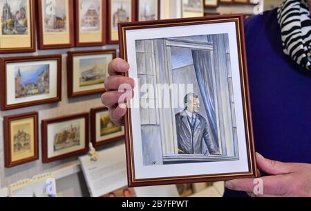 Erfurt, Deutschland. März 2020. Jürgen Valdeig, Zeitzeuge und Kunsthändler, zeigt am Fenster des Hotels "Erfurter Hof" ein selbstgemaltes Bild, das Bundeskanzler Willy-Brandt zeigt. Vor 50 Jahren, am 19. März 1970, war Willy-Brandt der erste Bundeskanzler, der einen Staatsbesuch in der DDR machte. Im Hotel "Erfurter Hof" gegenüber dem Bahnhof führte der SPD-Politiker Regierungsgespräche mit dem DDR-Ministerratspräsidenten Stoph. Es war das erste deutsch-deutsche Gipfeltreffen. Kredit: Martin Schutt / dpa-Zentralbild / dpa / Alamy Live News Stockfoto