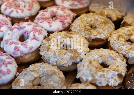 Viele verschiedene Schokoladenzucker-Donuts werden zum Verkauf angeboten. Stockfoto