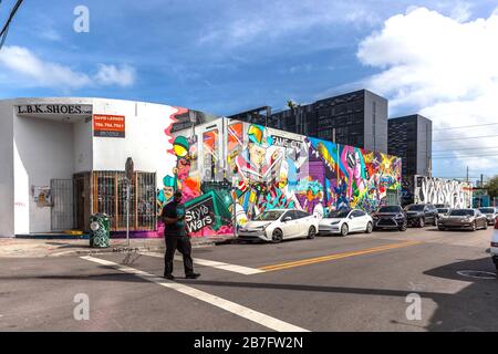 Ein Mann, der eine Straße im Wynwood Art District, Miami, Florida, USA durchquert. Stockfoto