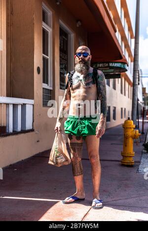 Porträt eines tätowierten bärtigen Mannes in Trunks, South Beach, Miami Beach, Florida, Großbritannien. Stockfoto