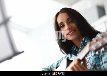 Das akustische Instrument zu spielen bringt Mädchen Freude Stockfoto