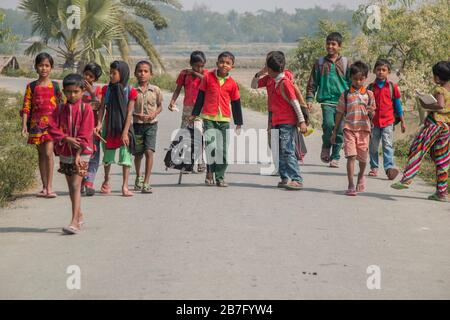 Bangladeschische Schulkinder, die von der Schule zurückkehrten und ihre Tasche in einem kleinen Dorf in Khulna, Bangladesch, trugen Stockfoto