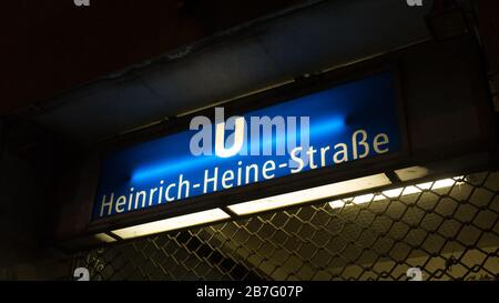 Schild über dem Eingang der U-Bahn-Station Heinrich-Heine-Straße. Benannt nach dem deutschen Dichter. Beleuchtetes U-Bahn-Schild nachts / im Dunkeln. Stockfoto