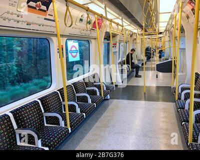 Eine spärlich besetzte District Line Kutsche in einem U-Bahn-Zug im Westen Londons so viele Büroangestellte in der Hauptstadt entschieden sich, von zu Hause aus zu arbeiten. Stockfoto