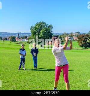 Attraktive junge Frau, die Golf spielt Stockfoto