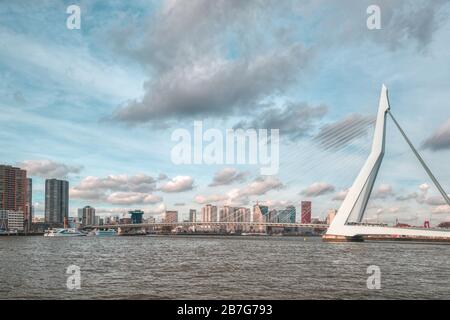 Rotterdam - 12. Februar 2019: Rotterdam, die Skyline der niederländischen Innenstadt in der Dämmerung in Südholland, Rotterdam, Niederlande. Rechts die Erasmus-Brücke Stockfoto