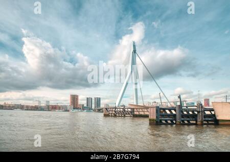 Rotterdam - 12. Februar 2019: Rotterdam, die Skyline der niederländischen Innenstadt in der Dämmerung in Südholland, Rotterdam, Niederlande. Pfähle im Wasser davor Stockfoto