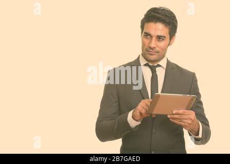 Jungen schönen persischen Geschäftsmann mit digitalen Tablet beim Denken Stockfoto