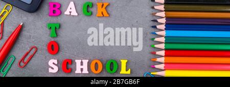 Das Layout von Schulmaterial auf einem dunkelgrauen Hintergrund. Die Aussicht von oben. Zurück zu Schule. Flach Stockfoto