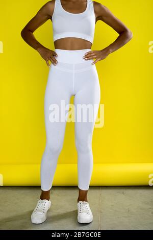 Junge afroamerikanische Frau in weißen, leergeweißen Leggings und einem Fruchtoberteil. Mock-up. Stockfoto