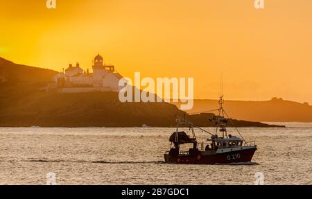 Roches Point, Cork, Irland. März 2020. Fischerboot Muir Einne passiert den Leuchtturm Roches Point, während die Sonne gerade im County Cork, Irland, aufsteigt. - Credit; David Creedon / Alamy Live News Stockfoto