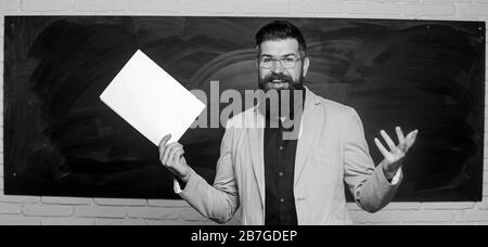 Lehrer Schreibarbeit. Schulleiter. Anspruchsvolle Lehrer. Dozent im Klassenzimmer. Erläuterung der Theorie. College und High School. Vorbereitungen für die Prüfung. Lehrer bärtiger Mann halten Dokumente Schiefertafel Hintergrund. Stockfoto