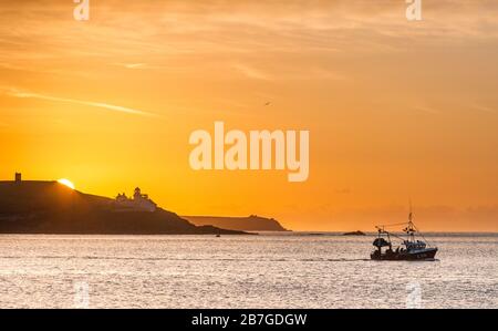 Roches Point, Cork, Irland. März 2020. Fischerboot Muir Einne passiert den Leuchtturm Roches Point, während die Sonne gerade im County Cork, Irland, aufsteigt. - Credit; David Creedon / Alamy Live News Stockfoto