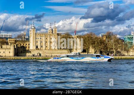 Thames Clipper Tornado an der Themse vorbei am White Tower des Tower of London. Stockfoto