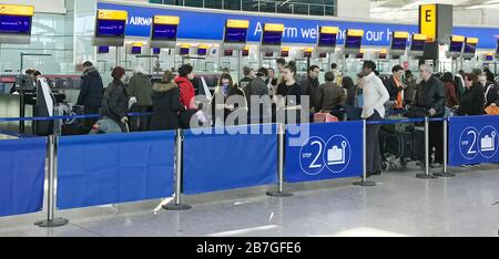 Passagiere suchen Informationen an den British Airways Desks am Terminal 5 des Londoner Flughafens Heathrow, nachdem die Flugpläne von der Muttergesellschaft IAG der Fluggesellschaft gekürzt wurden. Stockfoto