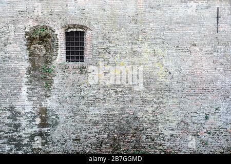 Alten, gemauerten Wand und Fenster mit Metallstangen gesperrt Stockfoto
