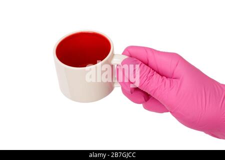 Weibliche Hand in Latexhandschuh, die eine leere Tasse auf einem weißen, isolierten Hintergrund hält Stockfoto