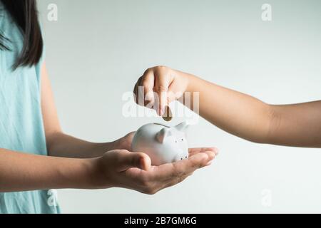 Sparen und Geschäftskonzept, zwei kleine Mädchen mit Sparkassen und Münzen zu Hause Stockfoto