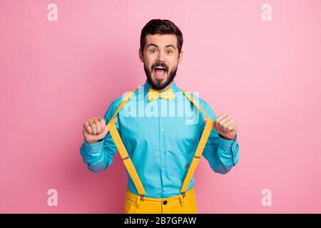 Porträt seines hübschen, trendigen, funky aufgeregt fröhlichen fröhlichen Glases mit imposanten, gut gekleideten bärtigen Kerl, der minzblaues Hemd trägt und Hosenträger zieht Stockfoto