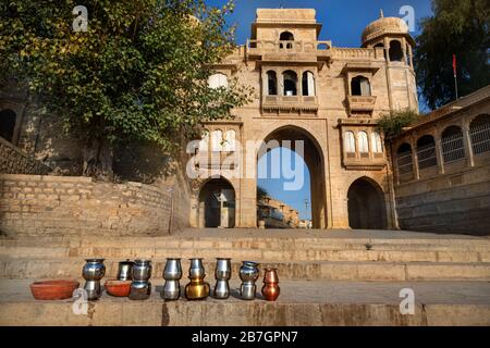 Tempel-Bogen in der Nähe von Gadi Sagar See und rituelle Eisentöpfe in Jaisalmer, Rajasthan, Indien Stockfoto