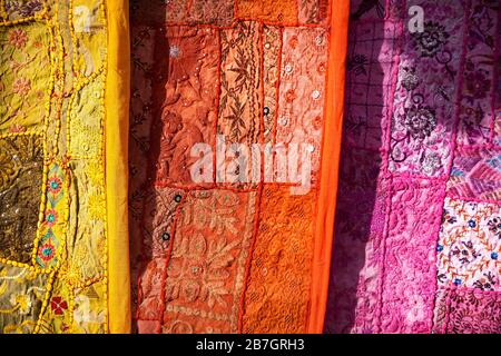 Stadtstraße Markt mit traditioneller Kleidung an der Wand von Jaisalmer Fort in Rajasthan, Indien Stockfoto