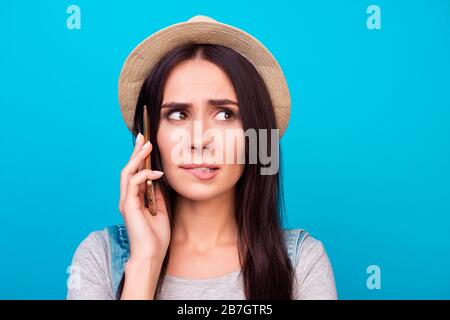 Nahaufnahme des Porträts der ziemlich unruhigen Frau, die Lippen beißt und um Hilfe auf dem Smartphone bittet Stockfoto